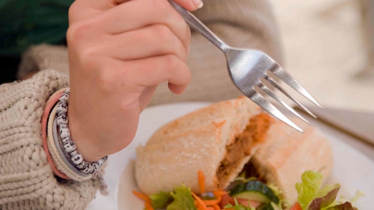 A close up of a sandwich at Glendurgan Garden with person holding a fork in front of it